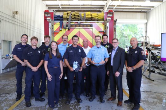 Group photo of firefighters and PenAir and Ascension Sacred Heart Foundation officials