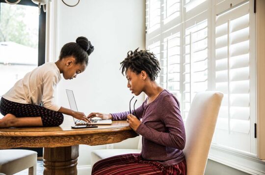 woman with daughter at table with laptop