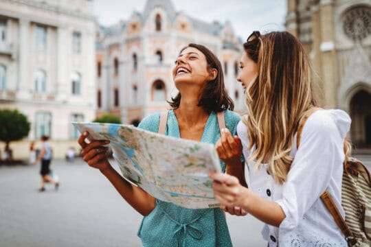 two women on vacation looking at map
