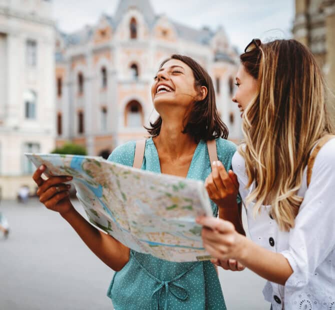 two women on vacation looking at map