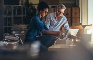 man and woman standing in front of a computer